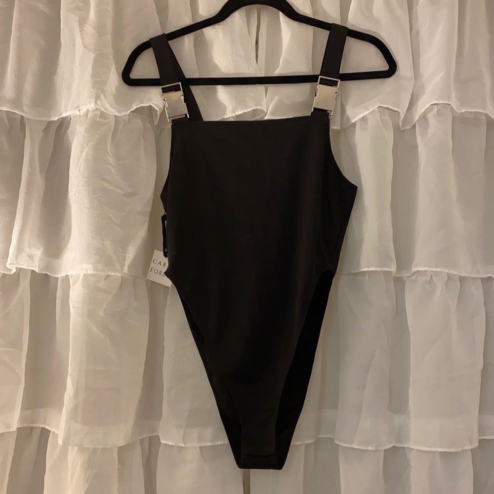 Caren Forbes black buckle body suit.